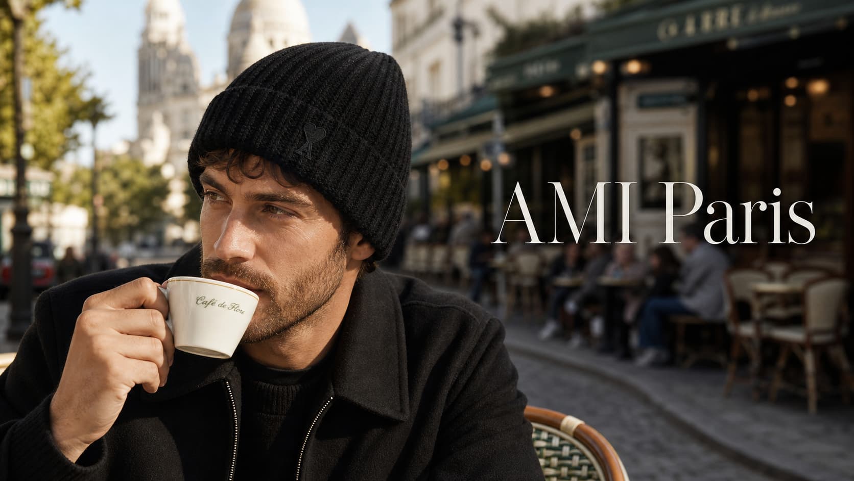 Un homme portant un bonnet noir AMI Paris boit un café en terrasse à Montmartre, avec un texte
