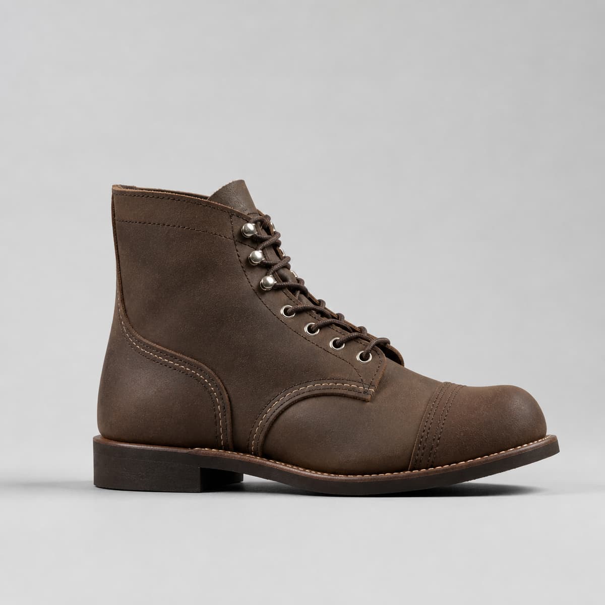 Botte Iron Ranger en cuir sombre texturé, vue de profil avec embout renforcé et crochets de laçage visibles, sur fond neutre.