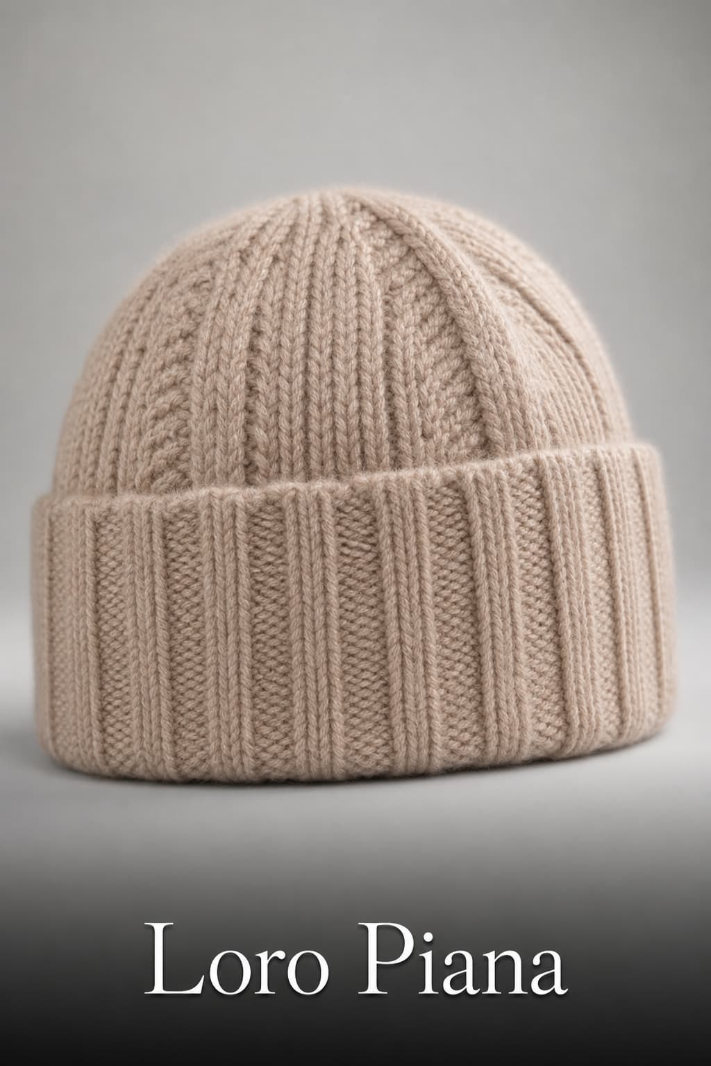 Gros plan en studio d'un bonnet en cachemire beige Loro Piana, plié soigneusement, mettant en valeur la texture fine du tricot, avec le texte